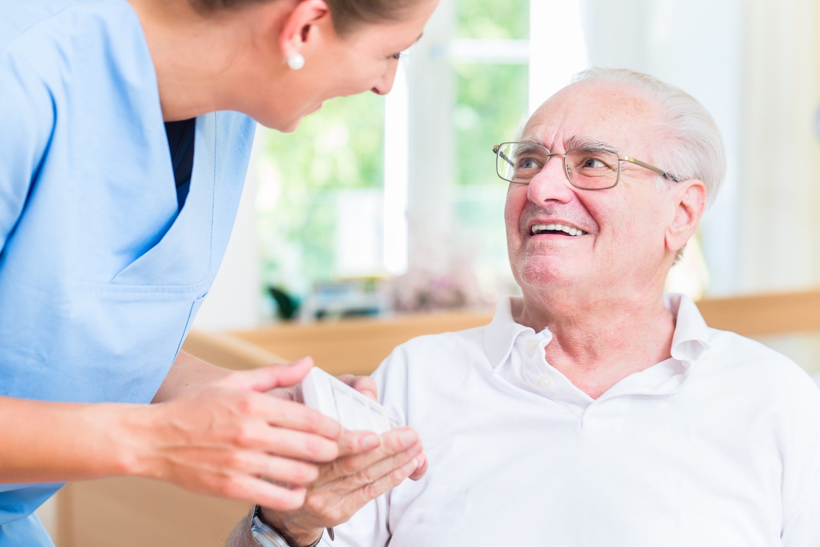 Nurse giving senior man prescription drugs